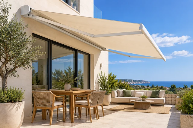 Tenda da sole a bracci estensibili con telo chiaro su una terrazza mediterranea
